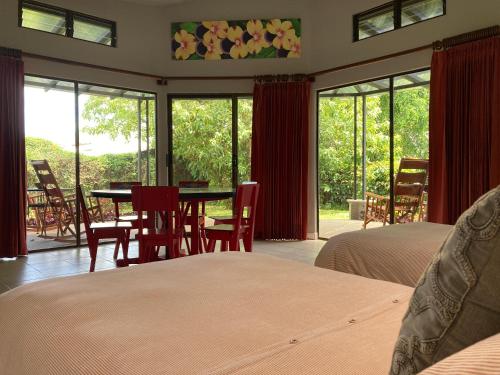 1 dormitorio con 2 camas, mesa y sillas en Villas Aracari, en Alajuela
