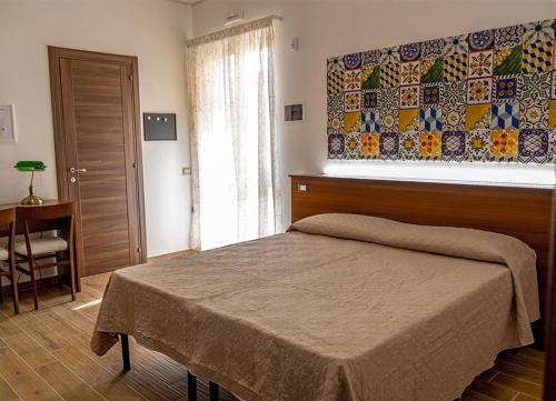 a bedroom with a bed and a table and a window at ZAHRA AGRITURISMO in Acireale