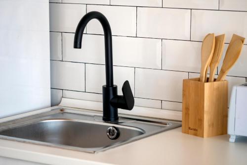 a kitchen sink with a black kitchen faucet at LOFT CANET DE MAR CERCA de BARCELONA in Canet de Mar