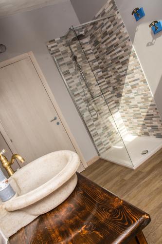 a bathroom with a sink and a glass shower at B&B Miellò nelle Langhe in Mango