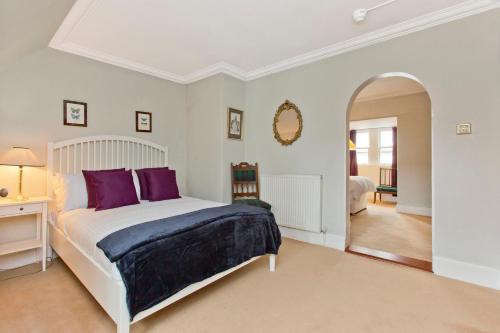 a bedroom with a large white bed with purple pillows at Dalnaglar Castle in Blairgowrie