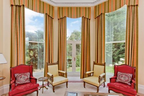 a living room with two chairs and a large window at Dalnaglar Castle in Blairgowrie