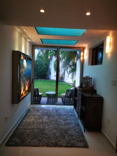 a living room with a large sliding glass door with a television at Spacious Home with Centric Location in Cancún