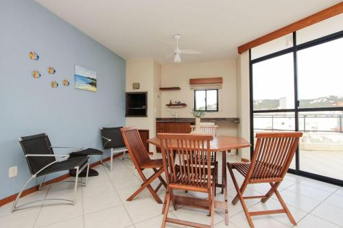 a kitchen and dining room with a table and chairs at Ilhas Cayman 133 – Linda Cobertura Duplex com Piscina Privativa a 120 Metros da Praia de Bombas. in Bombas