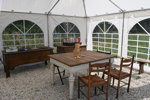 une tente avec une table et des chaises en bois. dans l'établissement Chateau Morinerie Glamping, à Villiers