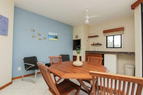 a dining room with a wooden table and chairs at Ilhas Cayman 133 – Linda Cobertura Duplex com Piscina Privativa a 120 Metros da Praia de Bombas. in Bombas