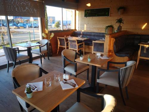 un restaurant avec des tables et des chaises dans une salle dans l'établissement Konine - Hotel & Bar & Restaurant, à Montceau-les-Mines