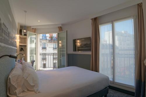 a hotel room with a bed and a large window at Appia La Fayette in Paris