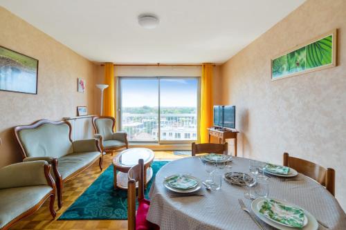 uma sala de estar com uma mesa e cadeiras e uma televisão em Nice 2 stars apartment with balcony - Vincennes - Welkeys em Vincennes