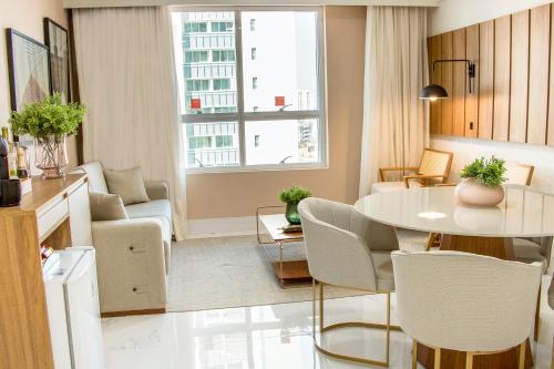 a small living room with a table and chairs at Ramada Hotel & Suites Campos Pelinca in Campos dos Goytacazes
