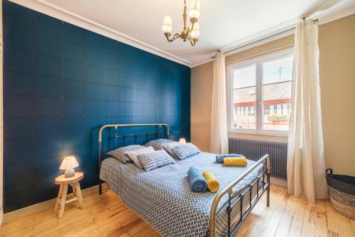 una camera blu con un letto e una finestra di Le Cépage de Sigo a Sigolsheim