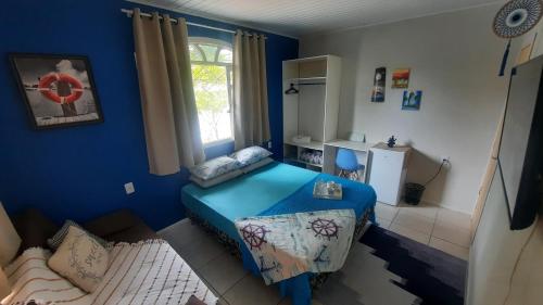 um quarto azul com uma cama e uma janela em Suíte Azul com SmartTv, Cama Queen e Banheiro Privativo em Itajaí