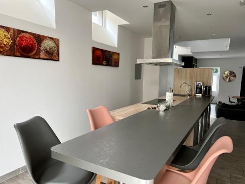 - une cuisine avec une table et des chaises dans l'établissement L'authentique Doloise Spa, à Dol-de-Bretagne