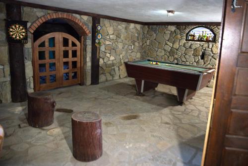 a game room with a pool table and a stone wall at Cabana Plăieșul in Tîrgu Neamţ