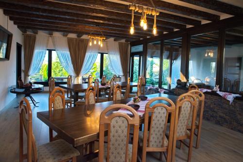 - une salle à manger avec une table et des chaises en bois dans l'établissement Cabana Plăieșul, à Tîrgu Neamţ