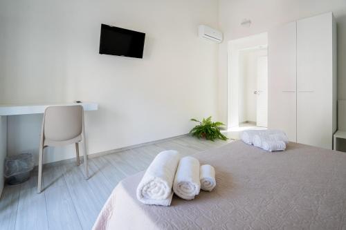 ein Schlafzimmer mit einem Bett mit Handtüchern darauf in der Unterkunft Harmonia Home Capitello in Capitello