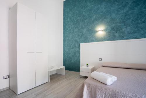 a bedroom with a bed and a green wall at Harmonia Home Capitello in Capitello
