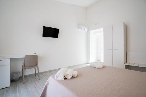 a white room with a bed with towels on it at Harmonia Home Capitello in Capitello