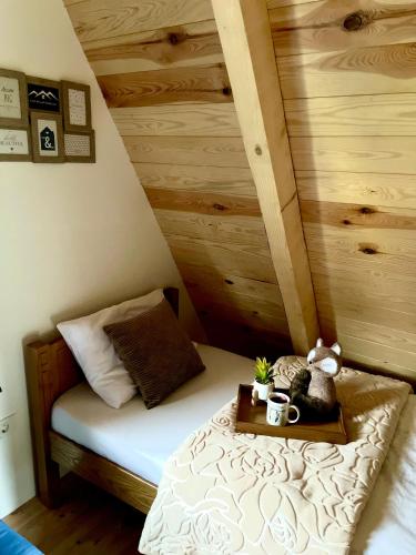 a small bedroom with a bed with a wooden wall at Lux Villas Zabljak in Žabljak