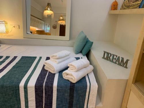 a bedroom with towels on a bed with a mirror at Lovely studio in Marbella close to Puente Romano in Marbella