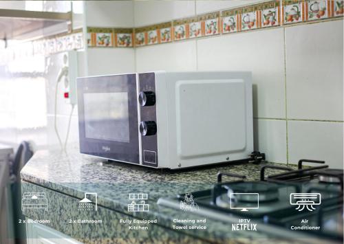 a microwave sitting on a counter in a kitchen at YourPlace Rabat Agdal 1 - Cozy Residence in Rabat