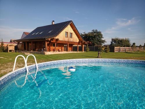 una grande piscina di fronte a una casa di srub U Holubů a Malšice
