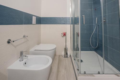 a bathroom with a shower and a toilet and a sink at Harmonia Home Capitello in Capitello