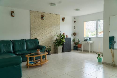 a living room with a green couch and a table at Hosteria Alma de Patagonia in El Chalten