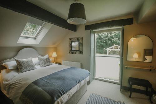 a bedroom with a bed and a window at Vicarage Farm Cottages in Tideswell