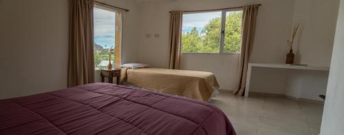 a bedroom with two beds and a window and a fireplace at Hosteria Alma de Patagonia in El Chalten