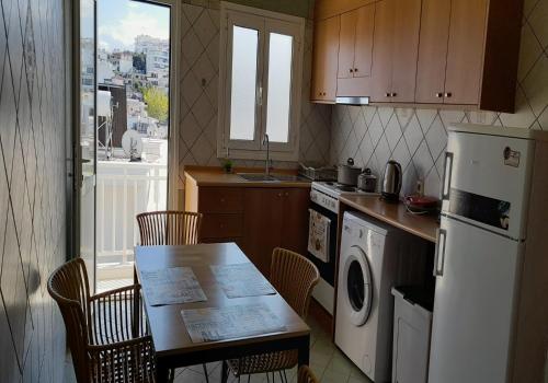 y cocina con mesa, sillas y nevera. en Gemani Apartments Rhodes city en Rodas