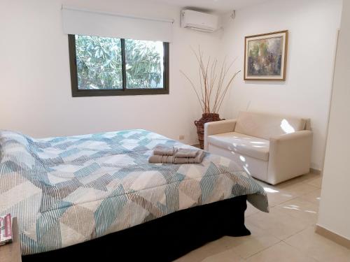 1 dormitorio con 1 cama y 1 silla en Hermoso departamento entero 2 Dormitorios con cochera B Urca en Córdoba