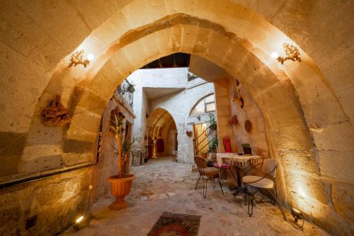 an archway in a building with a table and chairs at 7 Oda Kapadokya Cave Hotel in Urgup