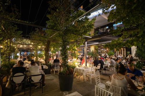 ludzie siedzący przy stolikach w restauracji w nocy w obiekcie Mustafa Suites we Wlorze