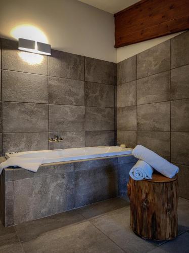 a bathroom with a bath tub and a wooden stump at Chalet Lago in Taverna