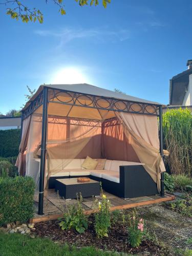 a couch in a tent in a yard at Großes Apartment mit Terrasse und Garten in Oberhaching