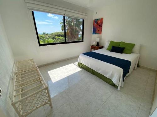 坎昆的住宿－Perla y Tropical By Andiani，一间卧室设有一张大床和一个窗户。