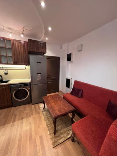 a living room with a red couch and a table at Dalv Residence - SPA Fairy Tale in old Sofia in Sofia