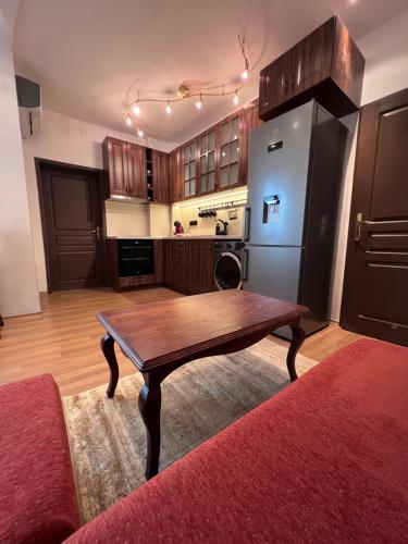 a kitchen with a wooden table and a refrigerator at Dalv Residence - SPA Fairy Tale in old Sofia in Sofia