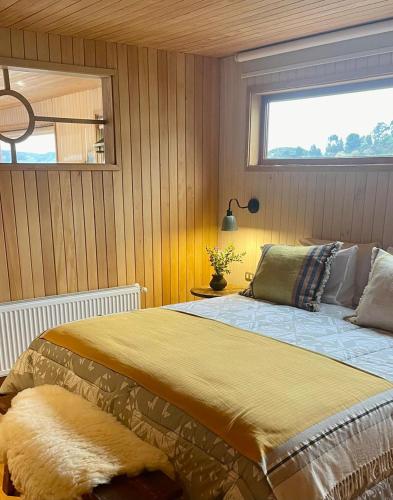 a bedroom with a large bed with a window at Bledford Chiloé in Castro