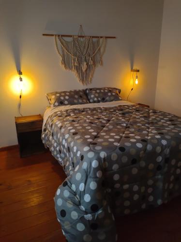 Un dormitorio con una cama grande con dos lámparas. en Rossi, en Malargüe