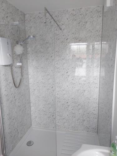 eine Dusche mit Glastür im Bad in der Unterkunft No 2 New Buildings Morebattle in Morebattle