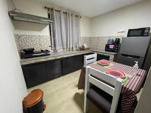 a small kitchen with a table and a refrigerator at Tenexia - La Gaulette Studio in La Gaulette