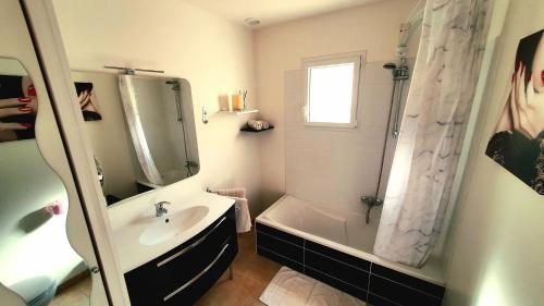 uma casa de banho com uma banheira, um lavatório e um chuveiro em La Bergeronnette em Saint-Paul-en-Forêt