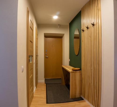 a hallway with a bathroom with a sink and a mirror at Apartamentai Tytuvėnuose in Tytuvėnai
