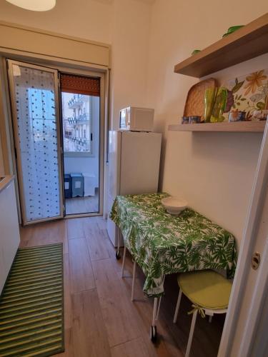 um pequeno quarto com uma mesa e um frigorífico em Happy Home em Catânia