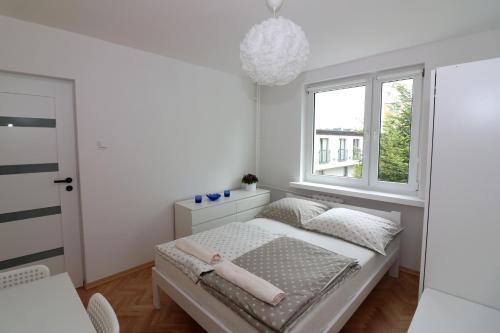 biała sypialnia z łóżkiem i oknem w obiekcie AAPARTAMENT w mieście Gdynia