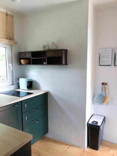 a kitchen with green cabinets and a counter top at Domek Pod Lasem in Trzciana