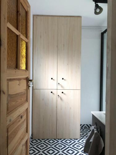 a room with a wooden cabinet and a black and white floor at Domek Pod Lasem in Trzciana