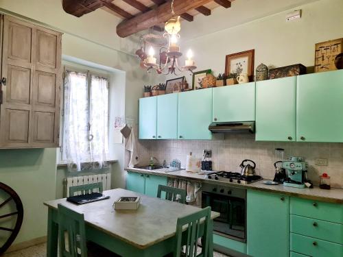 a kitchen with blue cabinets and a table with chairs at Le Rondini in Petrignano